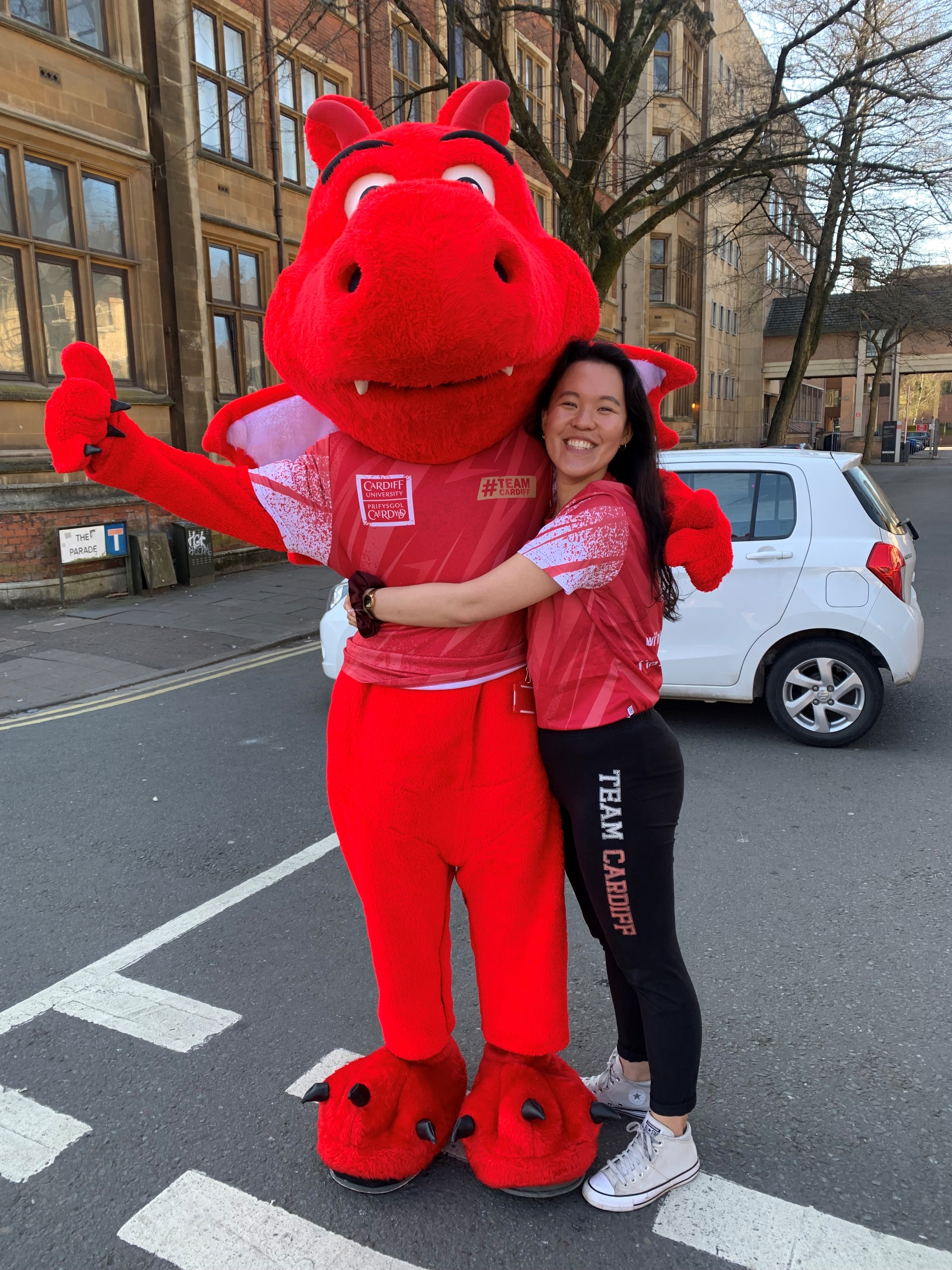 Jackie Yip hugging Cardiff's red dragon mascot.