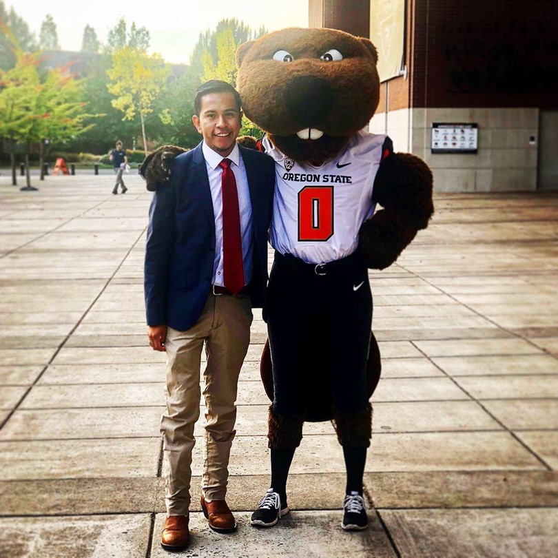 Jesus Rangel poses with Oregon University's Benny Beaver mascot--a human-sized beaver dressed in an OSU football jersey.