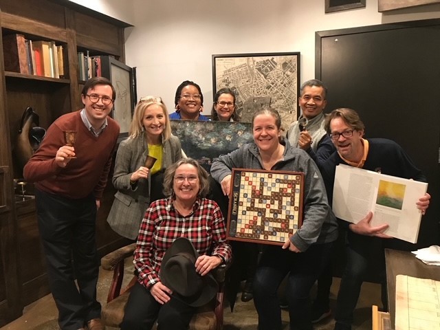 Shelley Greenwood and team posing triumphantly after completing an escape room.