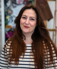 Headshot of Cyrielle Bazin, a white woman with long dark hair, wearing a white and black striped shirt.